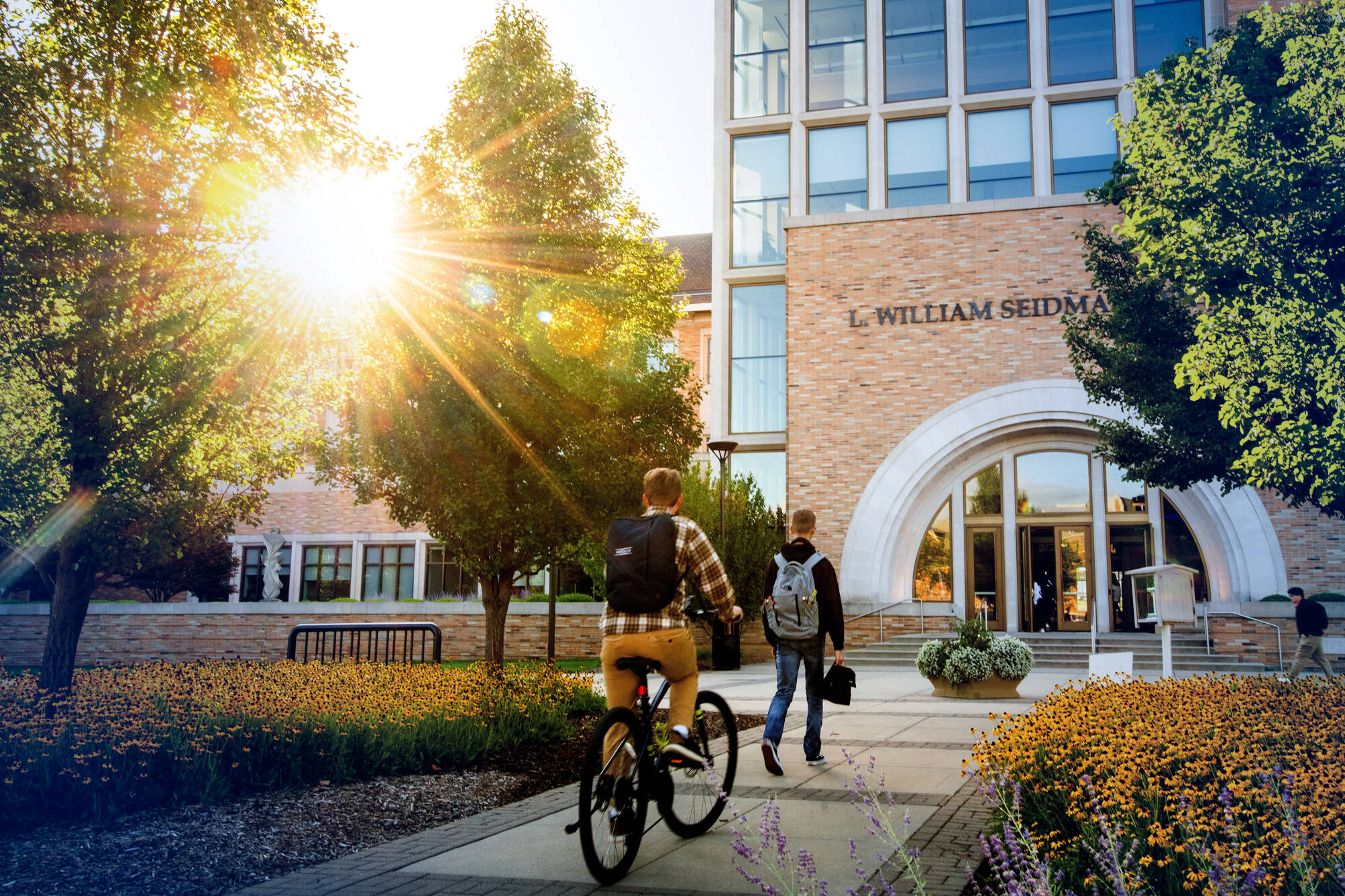 Two students walk towards the doors of the L William Seidman Center